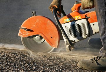 An image of a worker using a concrete saw to cut concrete.